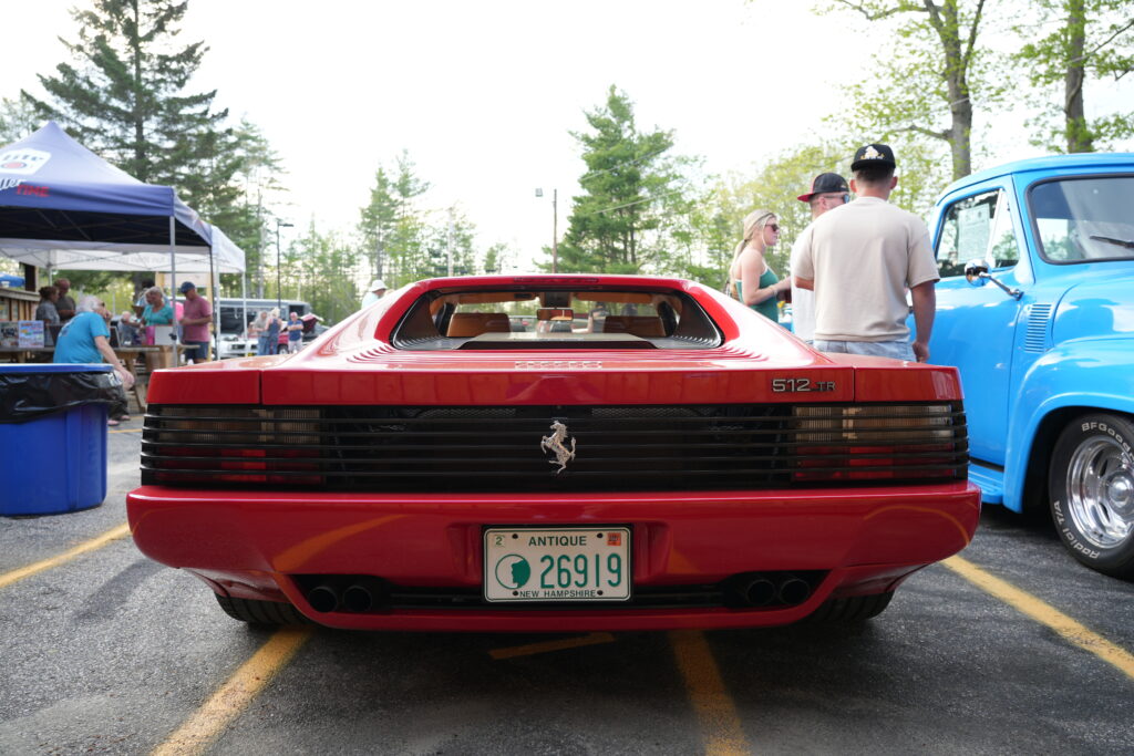 Rear deck and tail lights of a red Ferrari Testarossa at a car show