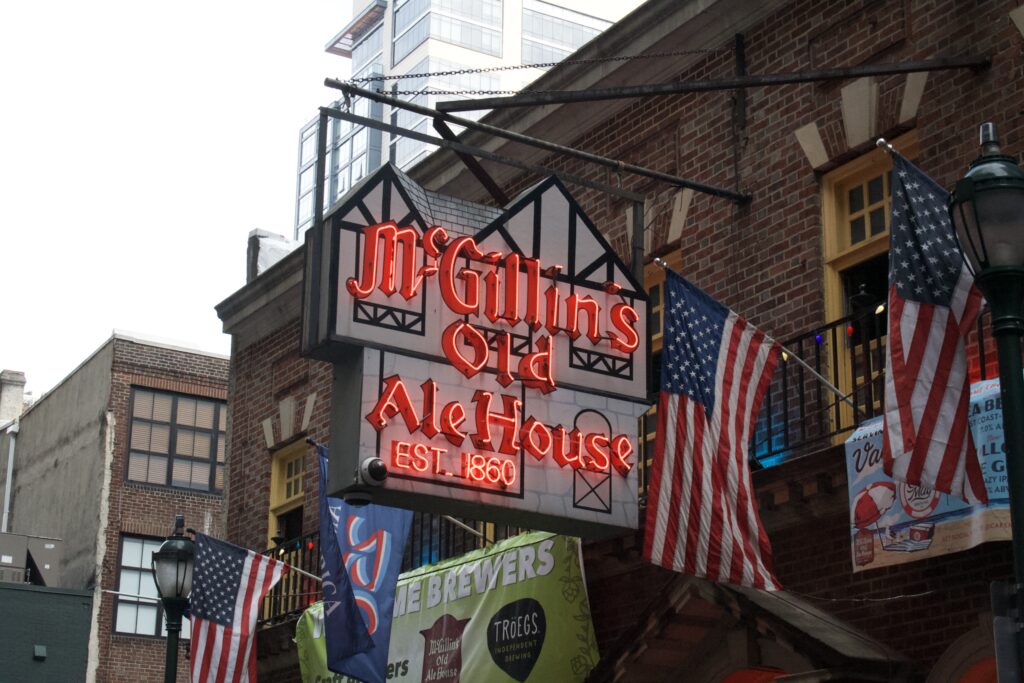 Historic McGillin's Olde Ale House sign and American flags, Philadelphia