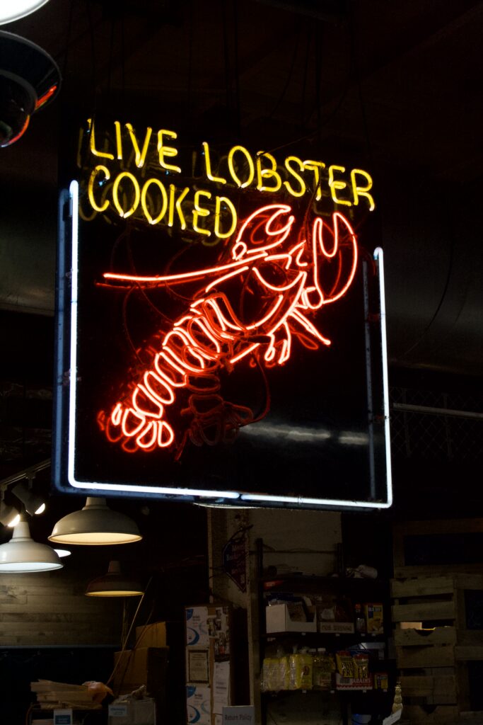 Red and yellow neon lobster sign glowing inside Reading Terminal Market