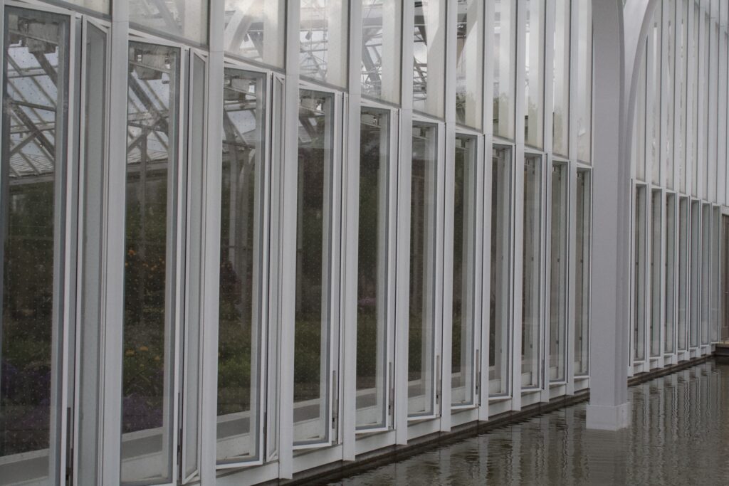 Repeating white steel mullions and glass panels of a conservatory wall