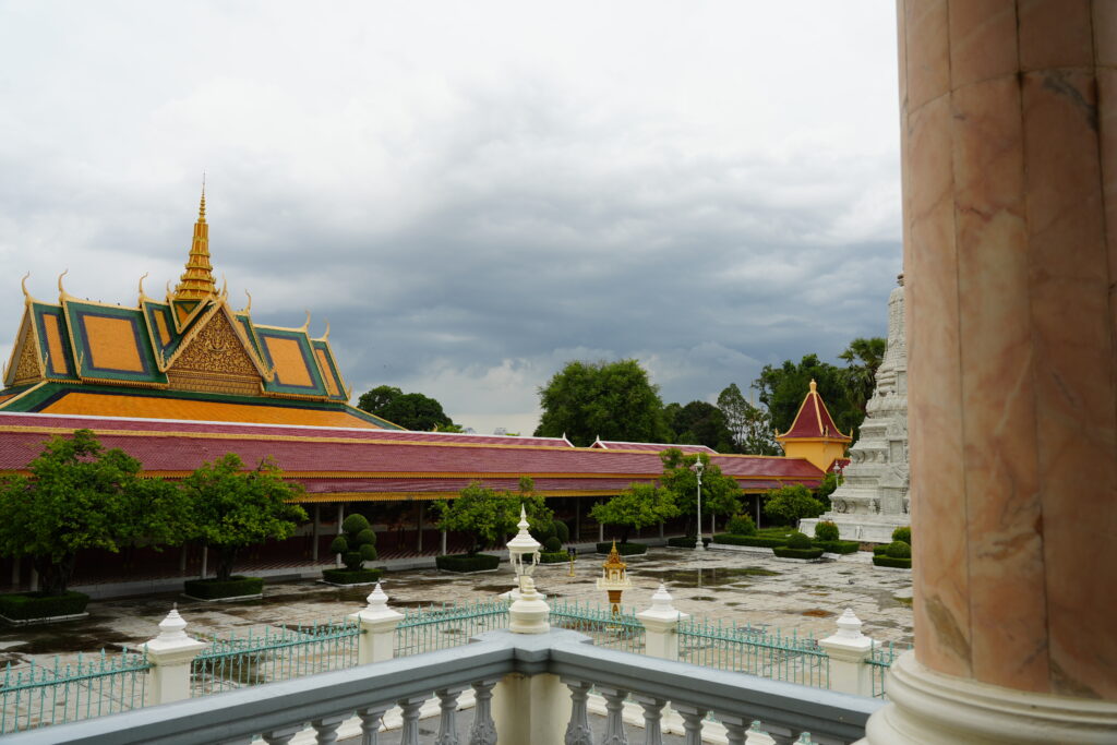 Royal Palace stupas and rooflines seen past a marble column