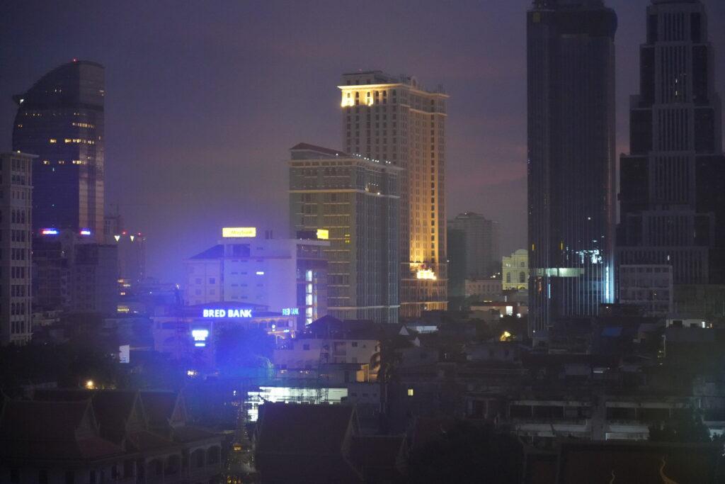 City towers glowing through humid haze at nightfall