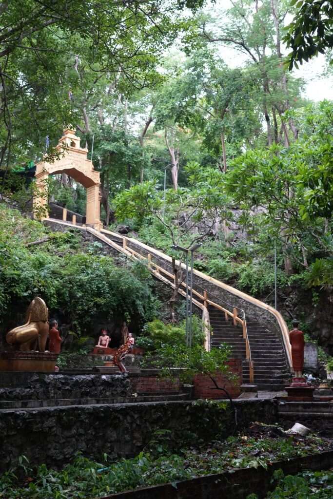 A golden arch and long stairway climbing into the trees