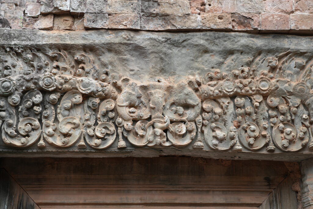 An intricately carved sandstone lintel of scrollwork and figures