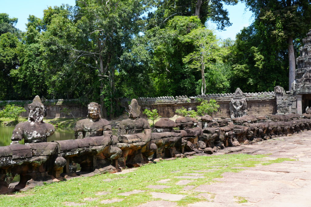 A row of stone guardian figures lining a temple bridge