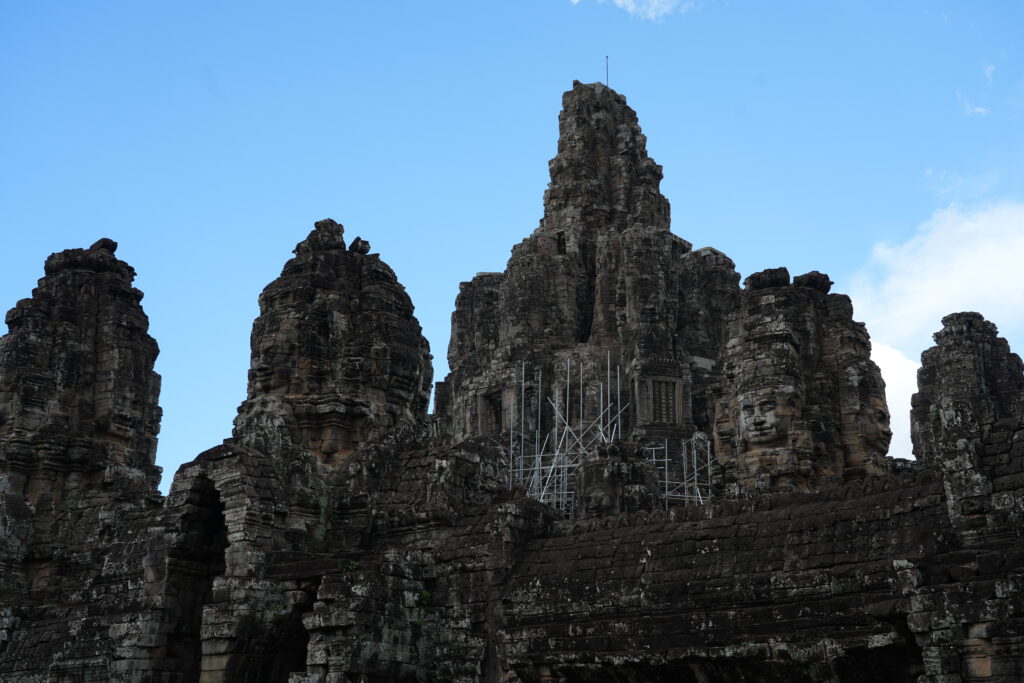 The clustered face towers of Bayon temple against blue sky