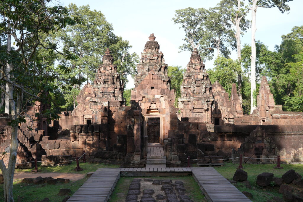 The pink sandstone towers of Banteay Srei framed by forest