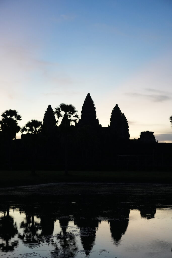 Angkor Wat in silhouette mirrored in the still reflecting pool