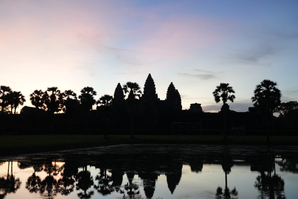 Pink dawn clouds over Angkor Wat reflected in the lotus pool