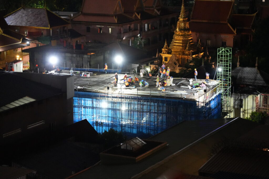 Golden stupa amid night construction