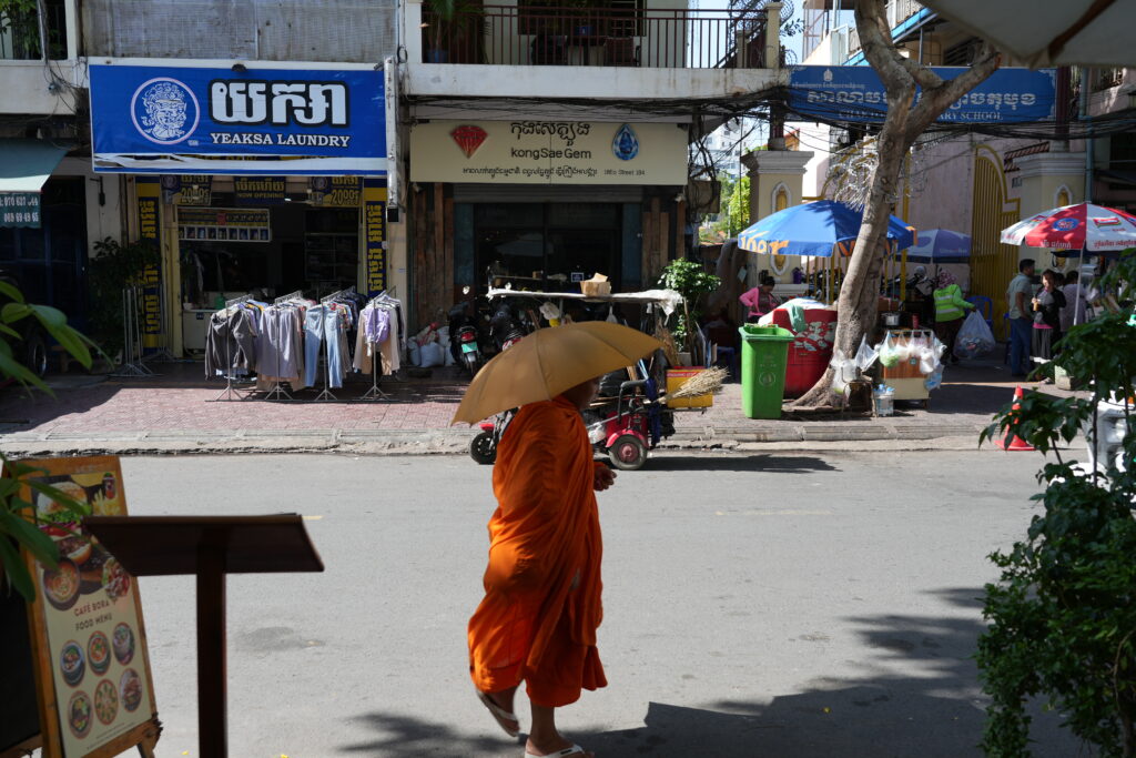 Monk with orange umbrella