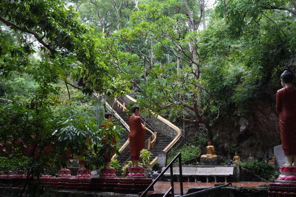 Monk statues below jungle temple staircase