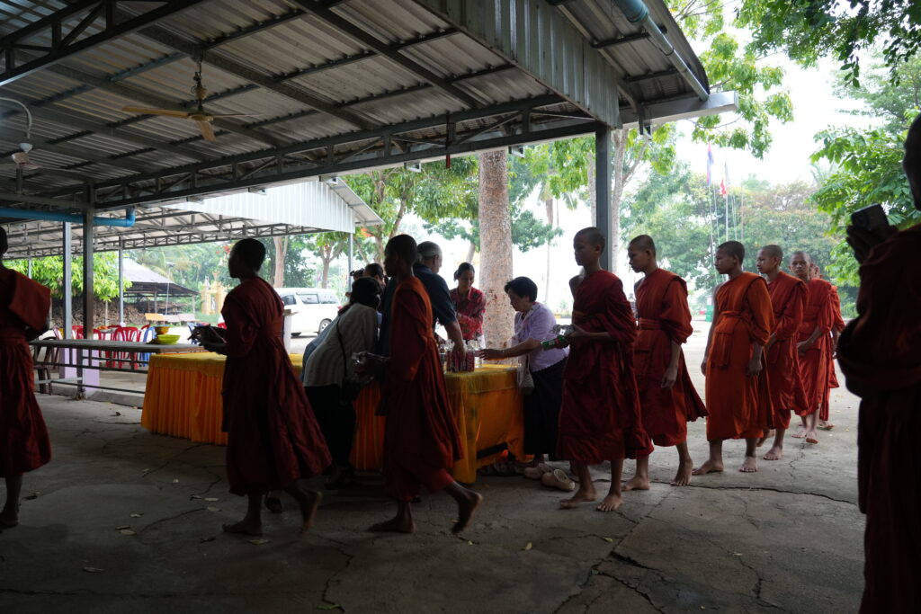 Line of monks receiving alms at temple