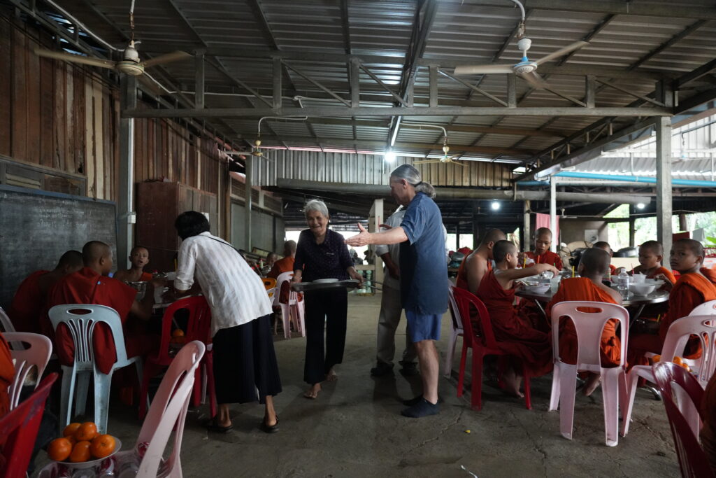 Elder woman greeting visitor in dining hall