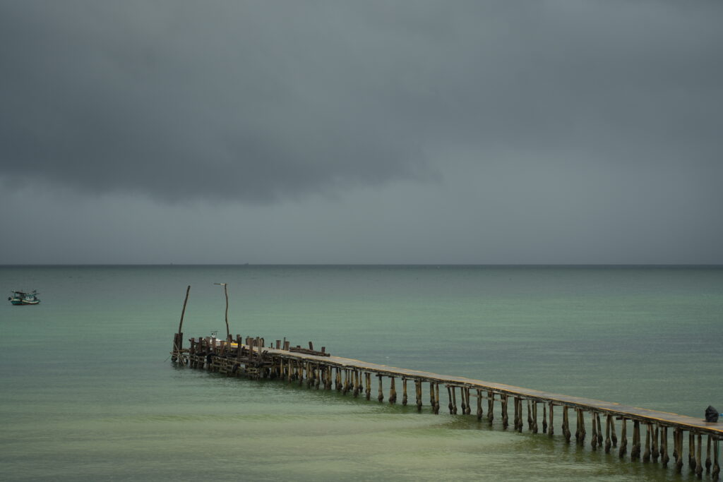 Weathered pier under storm sky