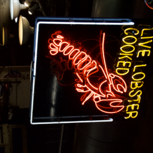 Red and yellow neon lobster sign glowing inside Reading Terminal Market