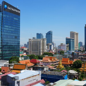 Glass towers rising behind the tiled roofs of a temple complex