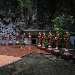 A row of robed Buddha statues in a limestone cave shrine