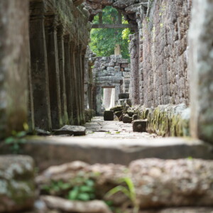 Carved blocks scattered along a ruined temple corridor