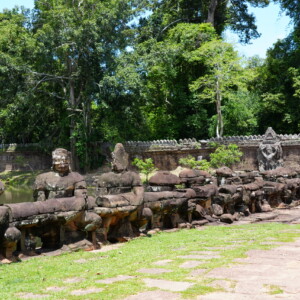 A row of stone guardian figures lining a temple bridge