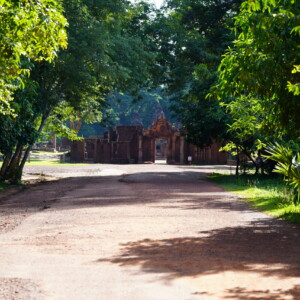 A red dirt road running straight to a distant temple gate