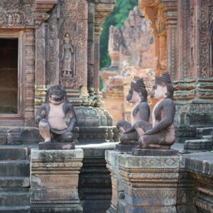 Kneeling guardian figures before the deeply carved temple wall